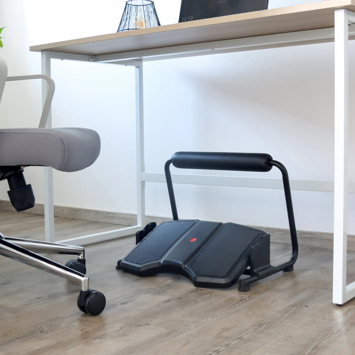 Schwarze Fußablage PODI F mit rutschfestem Tritt und gepolsterter Querstange unter einem Schreibtisch von hjh OFFICE