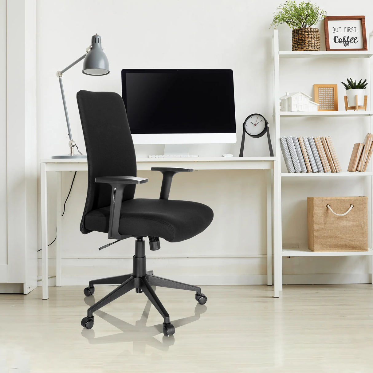 Schwarzer Homeoffice-Bürostuhl COSIO I mit Armlehnen und Rollen an einem weißen Schreibtisch von hjh OFFICE