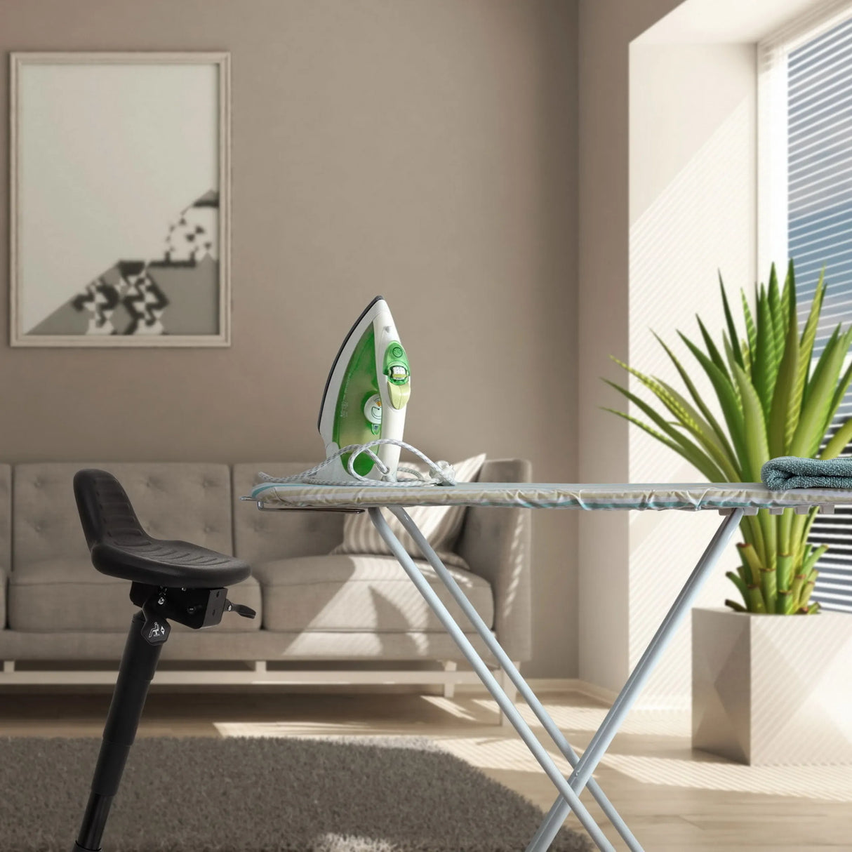 Schwarze Stehhilfe TOP WORK 34 neben einem Bügelbrett in einem hellen Raum von hjh OFFICE