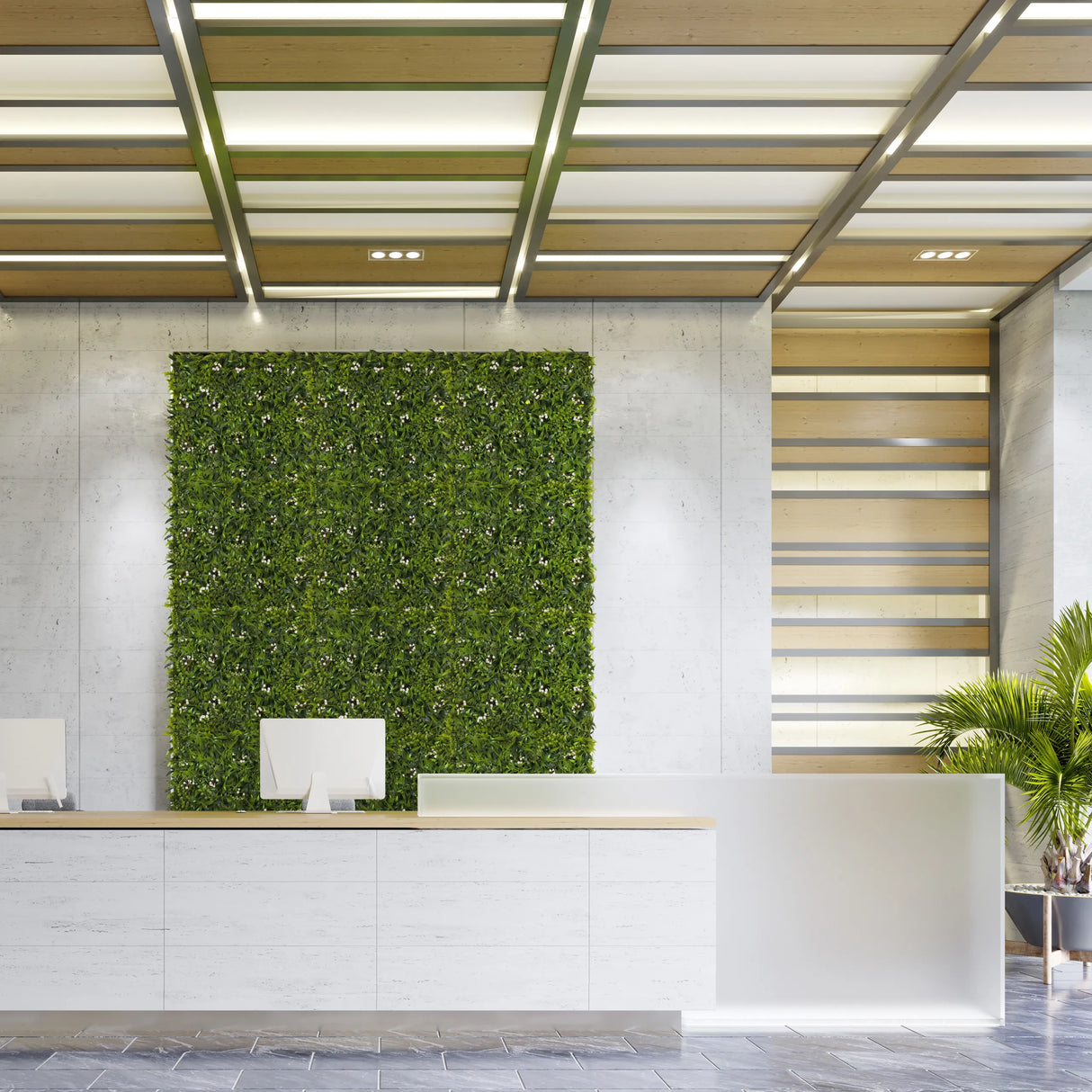 Grüne Pflanzenmatte MORE GREEN I als vertikale Begrünung an einer hellen Betonwand im Empfangsbereich von hjh OFFICE