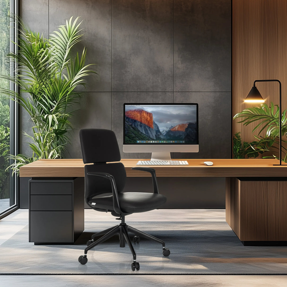 Schwarzer Profi-Bürostuhl ATMOS DESIGNER mit Armlehnen und Rollen an einem Schreibtisch von hjh OFFICE