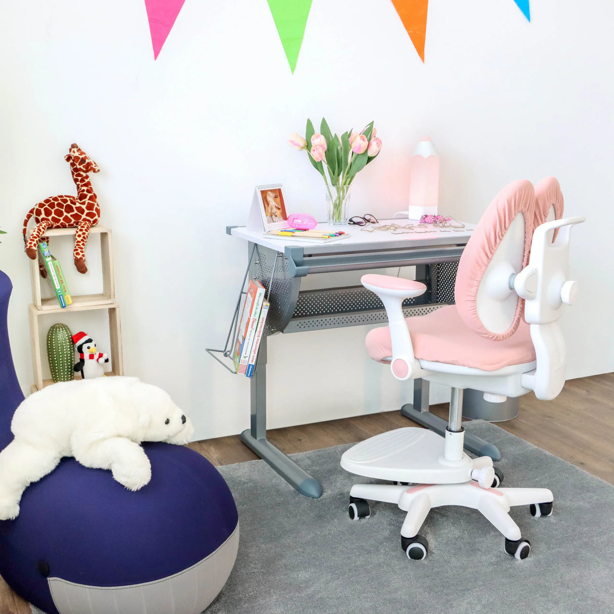 Rosa Kinderstuhl KID WING mit weißem Gestell und Rollen vor einem Kinderschreibtisch von hjh OFFICE