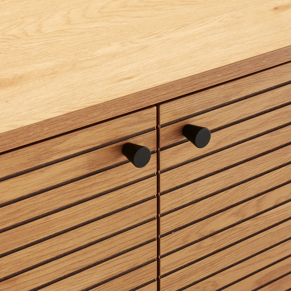 Gezinkte Fronten mit schwarzen Knäufen des Sideboards LINNO S in Eiche von hjh LIVING
