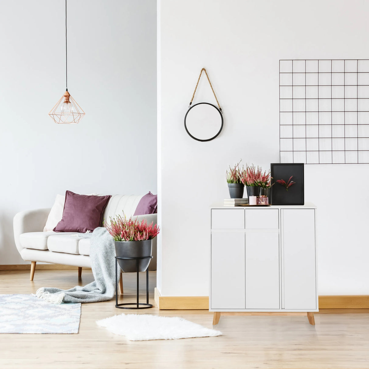 Weiße Kommode ESTHA mit zwei Türen und hellen Holzfüßen in einem hellen Wohnraum von hjh LIVING