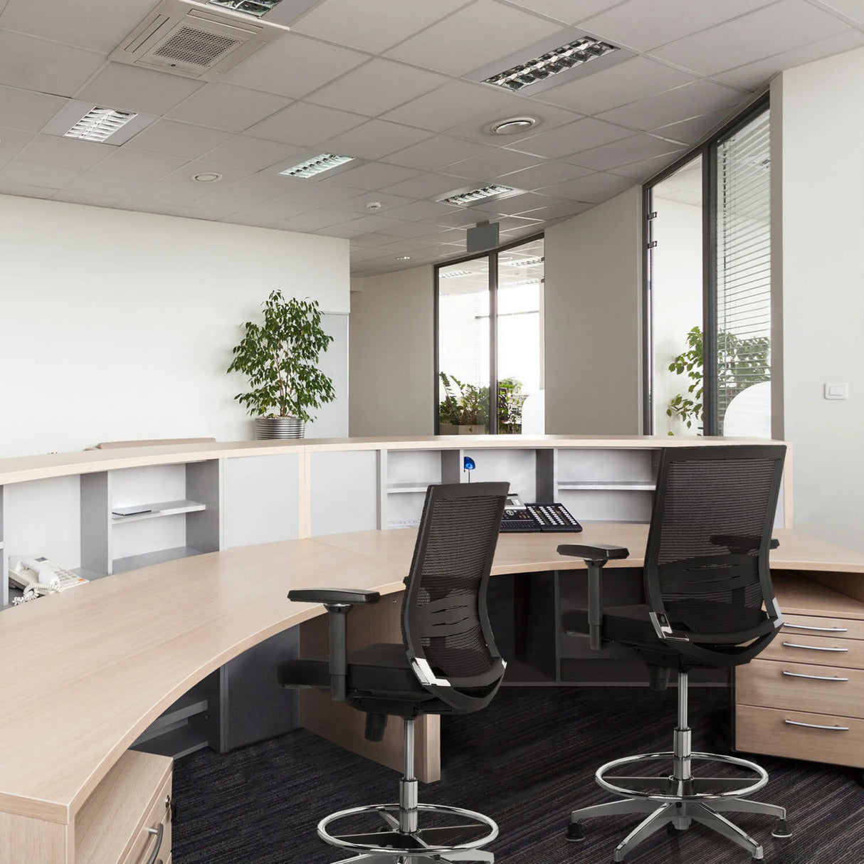 Zwei schwarze Counterstühle TOP WORK 77 mit Netzrücken und Fußring an einem Empfangstresen von hjh OFFICE