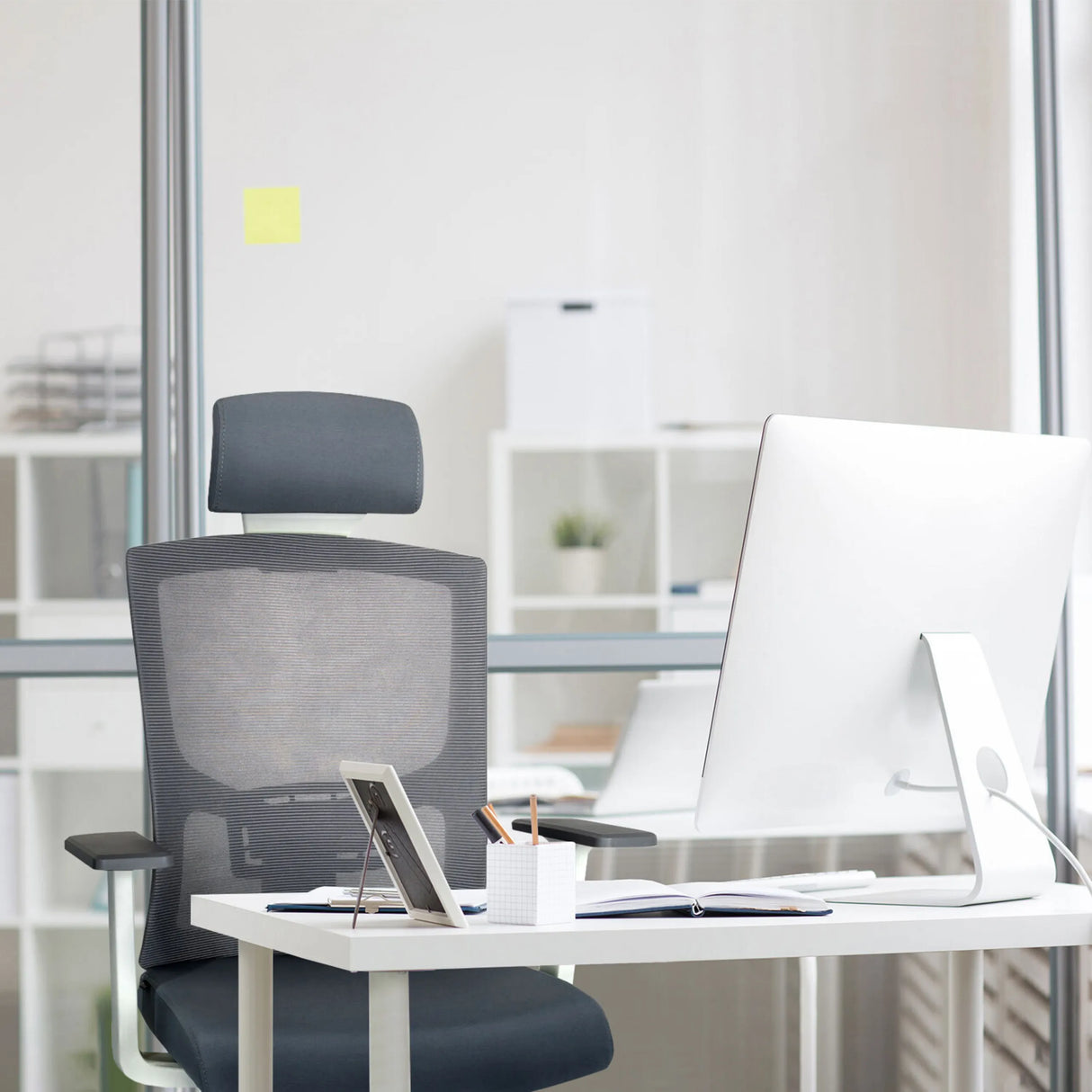 Grauer Profi-Bürostuhl CAPTIVO BASE W mit Netzrückenlehne und Kopfstütze an einem Schreibtisch von hjh OFFICE