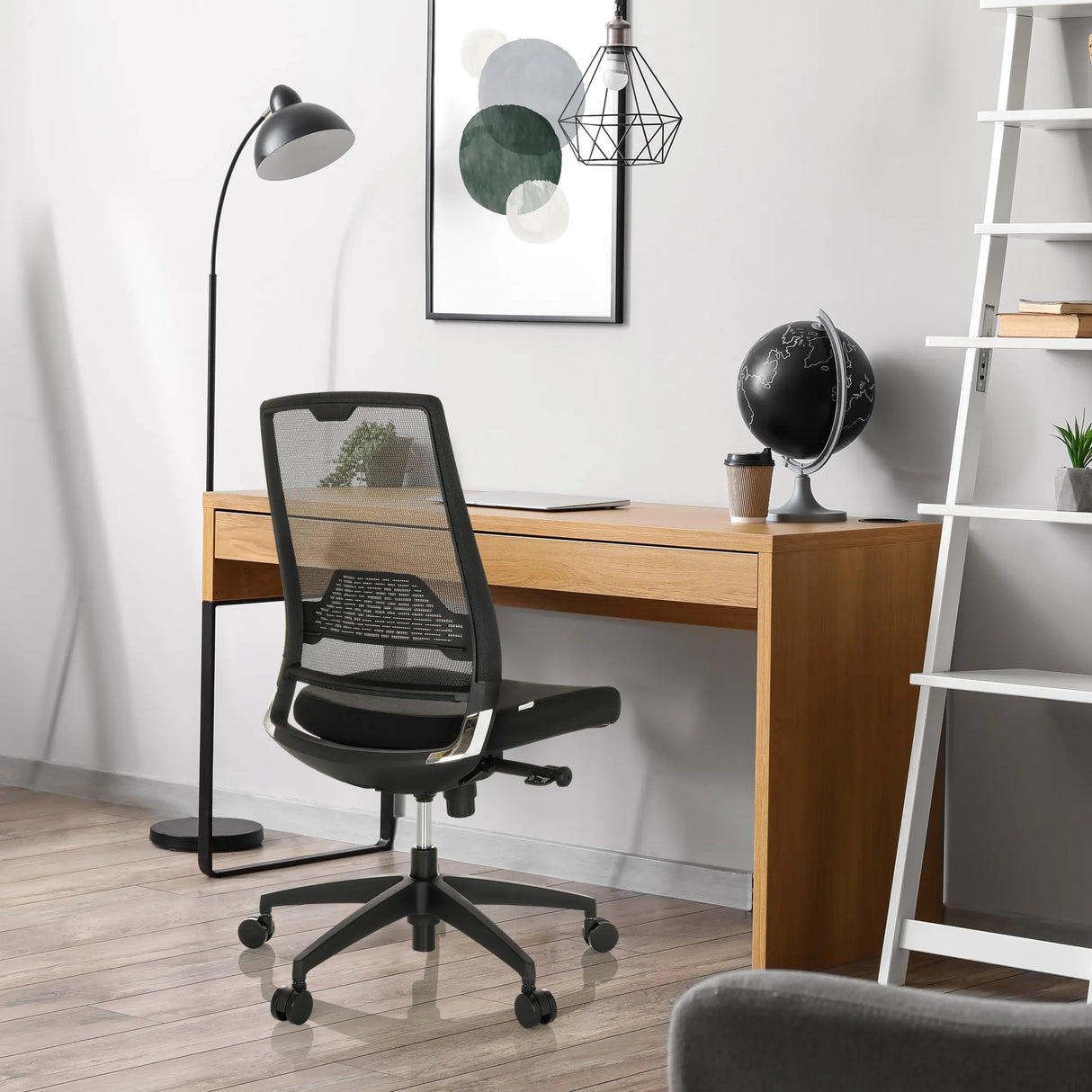 Schwarzer Profi-Bürostuhl PORTO ECO I mit Netzrückenlehne an einem Holzschreibtisch von hjh OFFICE
