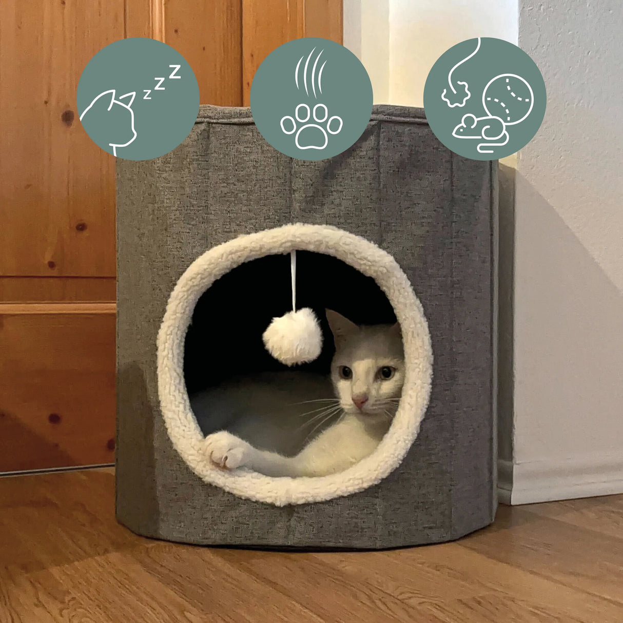 Graue Katzenhöhle PAWY R mit weißem Pelzrand, integriertem Spielball und einer Katze im Inneren von hjh LIVING