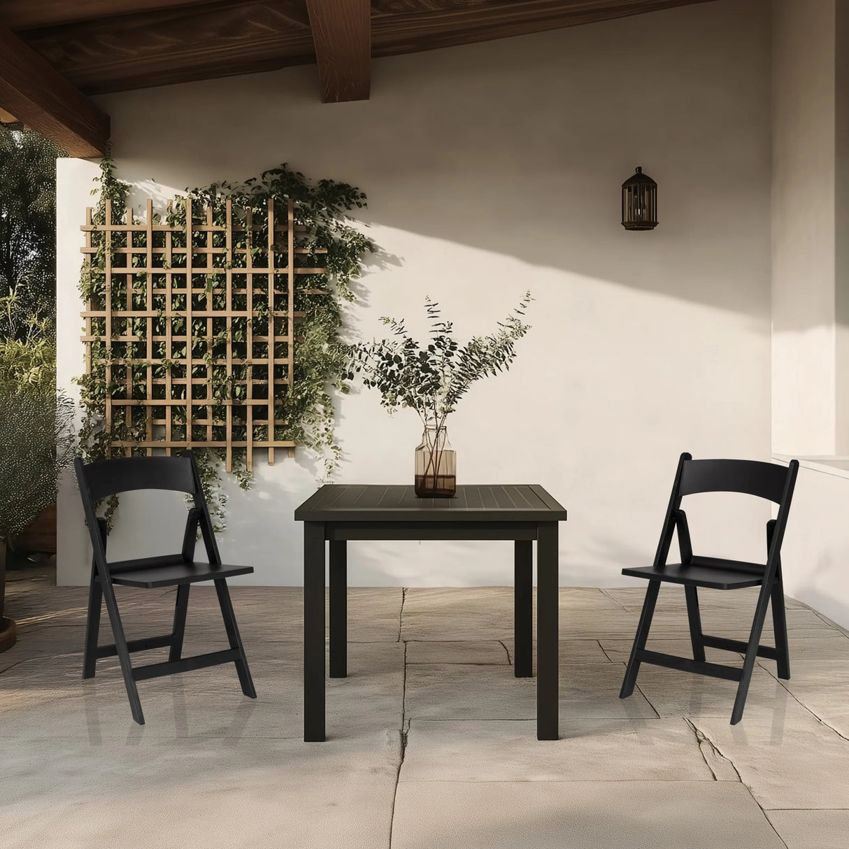 Zwei schwarze Outdoor-Stühle TRAVANO 1 mit passendem Tisch auf einer Terrasse von hjh LIVING