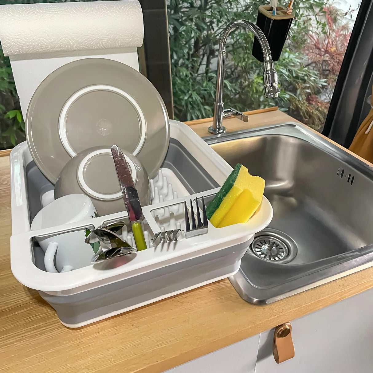 Grau-weißer Faltbehälter CLEAN SIL als Abtropfgestell mit Geschirr und Schwamm neben einer Spüle von hjh OFFICE