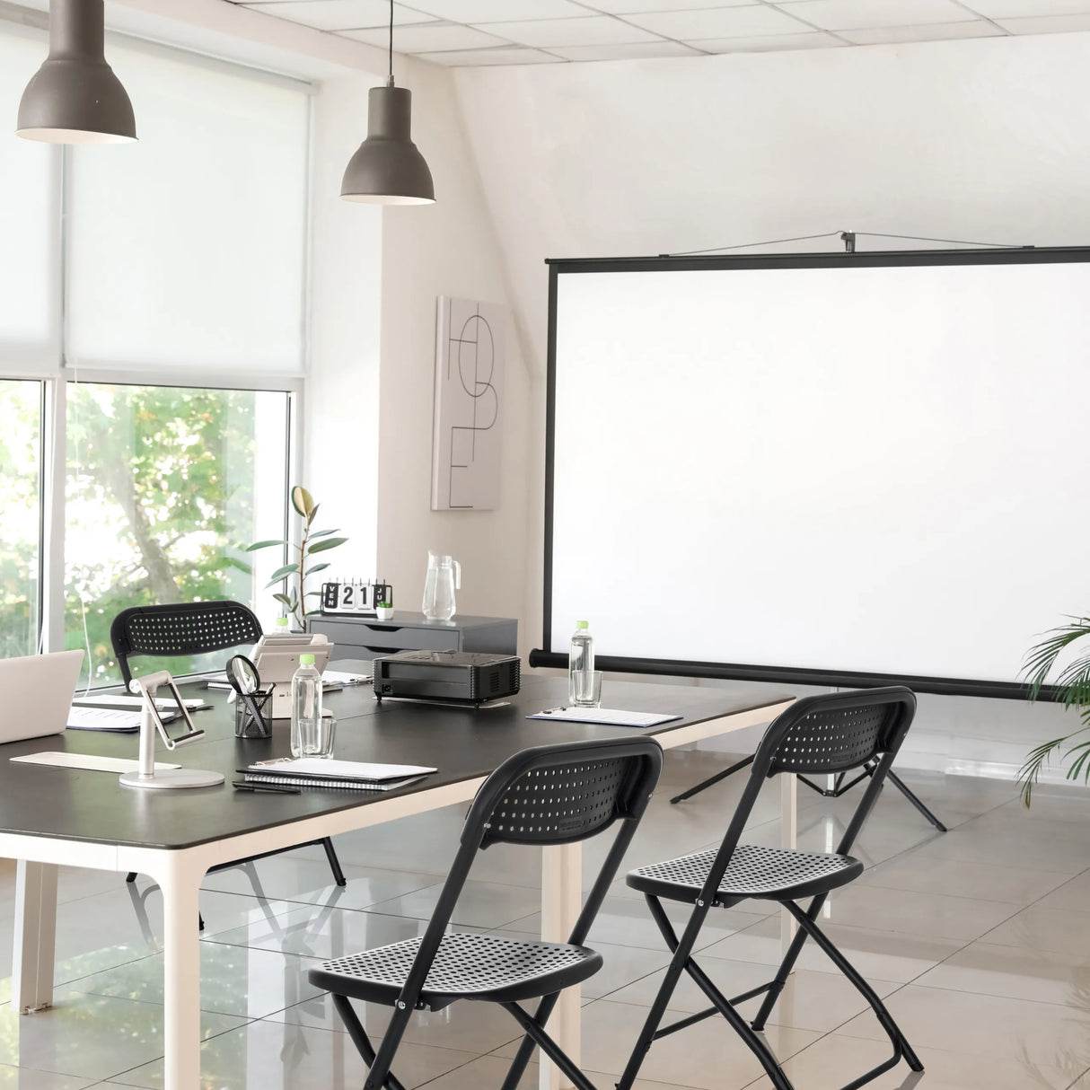 Zwei schwarze Outdoor Stühle TUDELA XXL PRO mit perforierter Sitzfläche an einem Tisch von hjh OFFICE