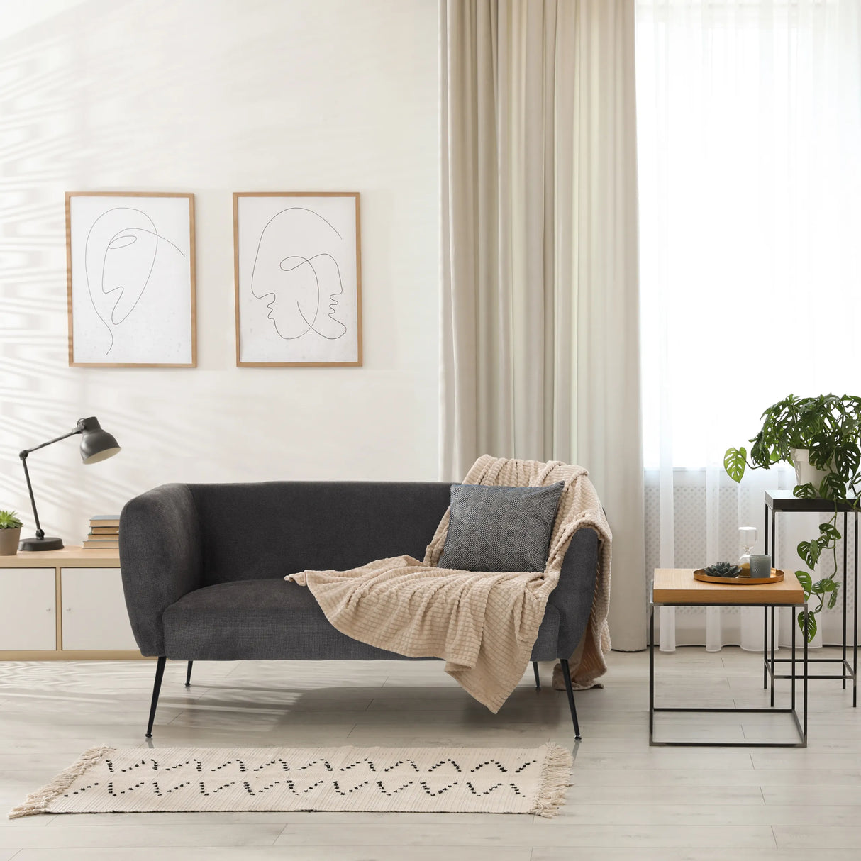 Graues Loungesofa HAYRIVER mit Kissen und Decke in einem hellen Raum von hjh LIVING