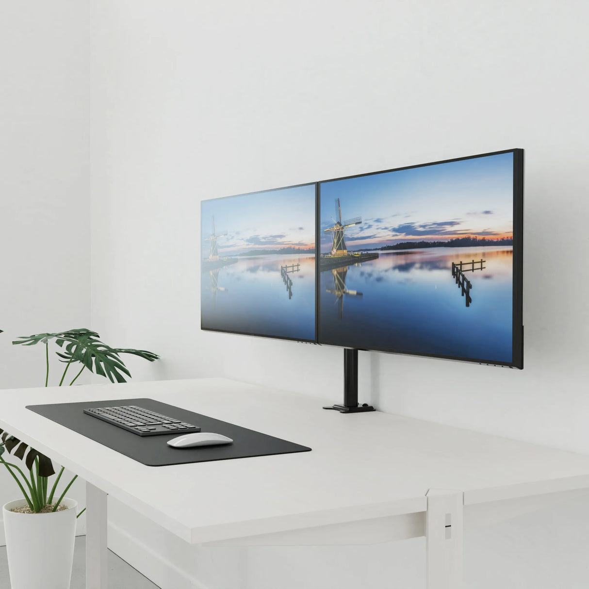 Schwarze Monitorhalterung Ergomount M2 für zwei Bildschirme auf einem weißen Schreibtisch von hjh OFFICE