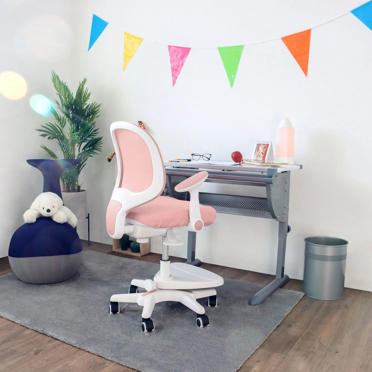 Rosa Kinderstuhl KID ERGO mit weißen Armlehnen und Rollen an einem Schreibtisch von hjh OFFICE