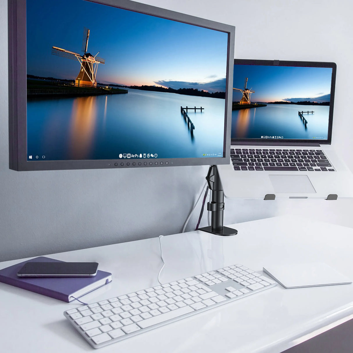 Schwarze Monitorhalterung VM-MH2 mit einem befestigten Bildschirm auf einem weißen Schreibtisch von hjh OFFICE
