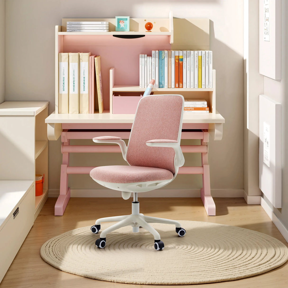 Rosa Kinderdrehstuhl Swivelo mit Armlehnen und Rollen an einem Schreibtisch von hjh OFFICE