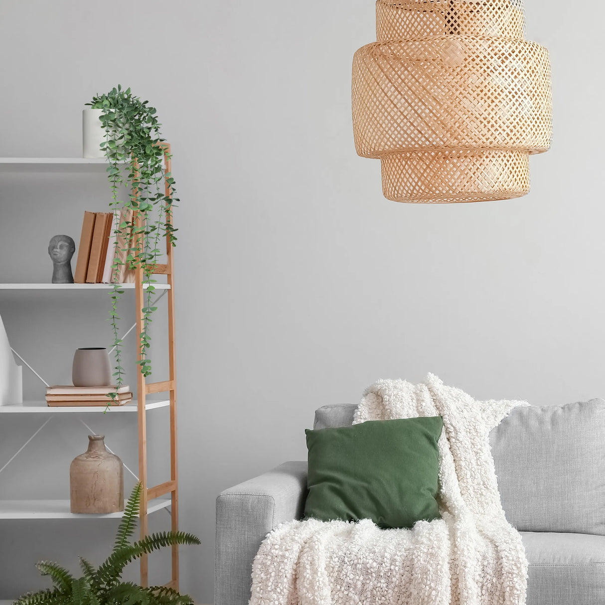 Grüne Kunstpflanze EUCALYPTUS CLIMB in einem Regal neben einem grauen Sofa von hjh OFFICE