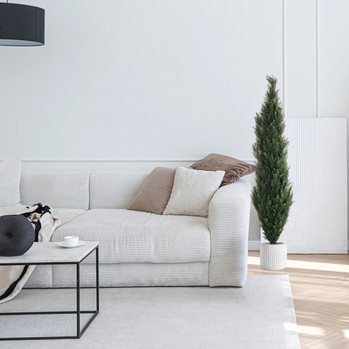 Grüne Kunstpflanze CEDRUS in einem weißen Topf neben einem weißen Sofa von hjh OFFICE