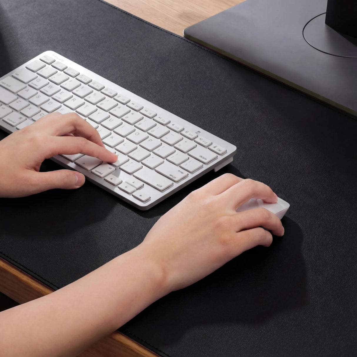 Schwarze Schreibunterlage Padflux Power mit einer weißen Tastatur und einer Computermaus im Gebrauch von hjh OFFICE