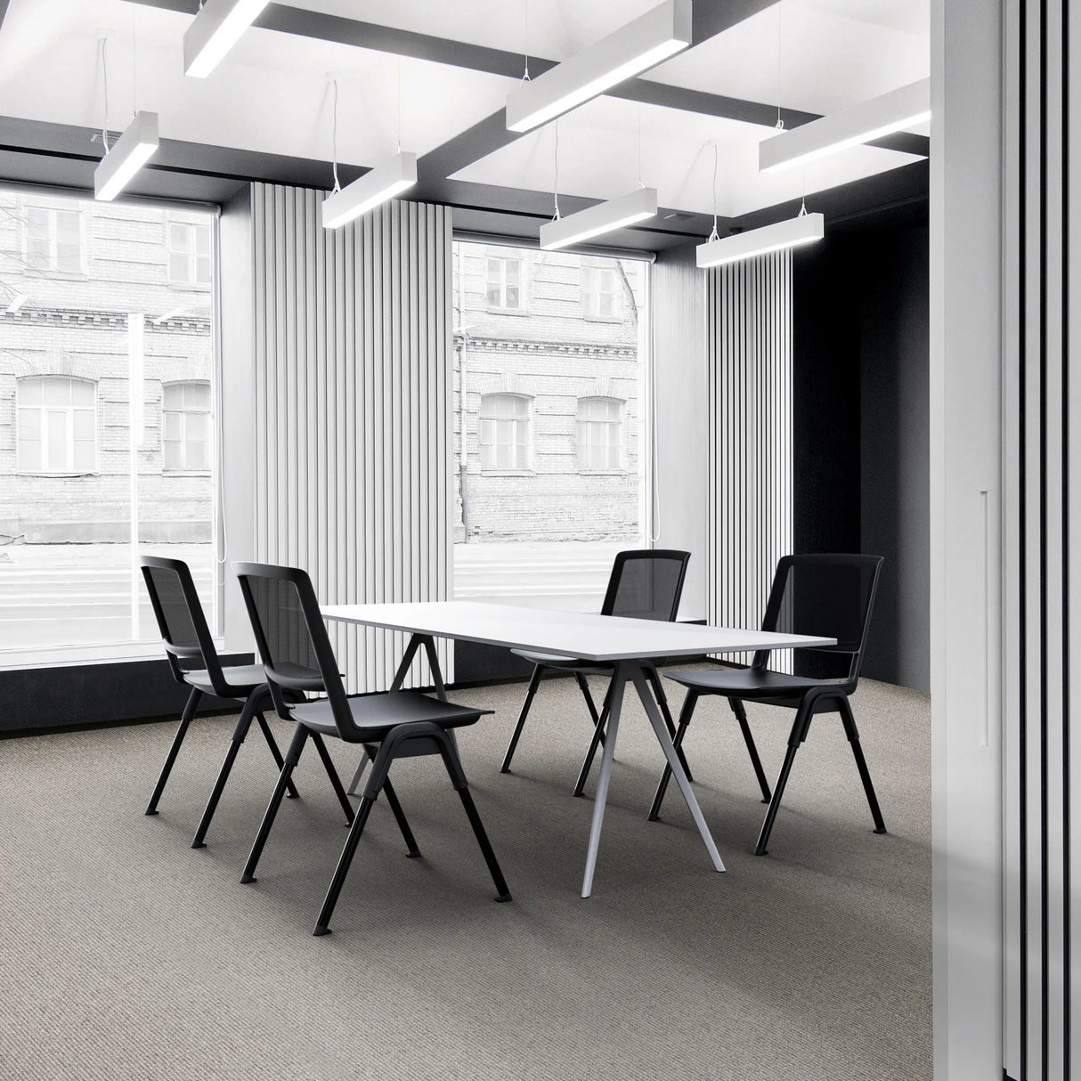 Vier schwarze Besucherstühle MEET WA an einem weißen Konferenztisch in einem modernen Büro von hjh OFFICE