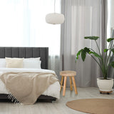 Brauner Sitzhocker RUSTIKO W aus Holz mit drei Beinen neben einem Bett von hjh LIVING