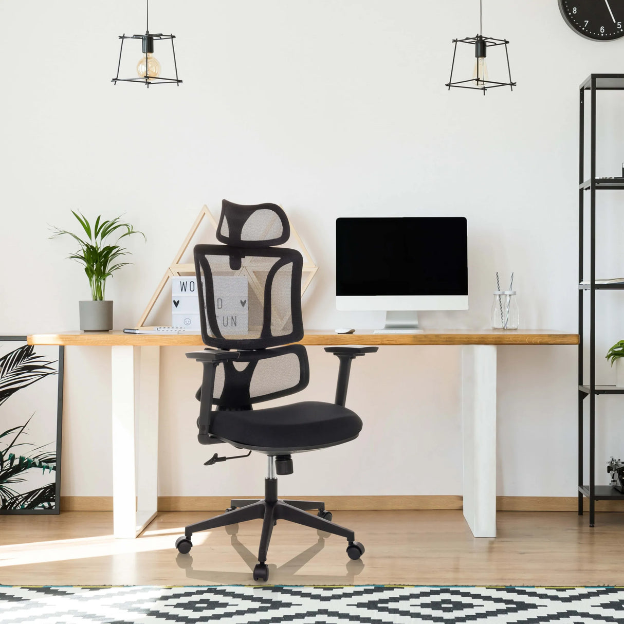 Schwarzer Homeoffice-Bürostuhl ERGOMY mit Netzrückenlehne und Armlehnen an einem Schreibtisch von MyBuero
