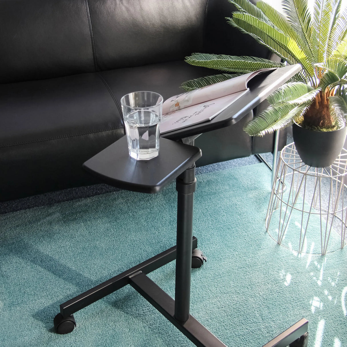 Schwarze Ablagefläche des Stehschreibtisches VM-SL mit Glas und Magazin auf einem Teppich von hjh OFFICE