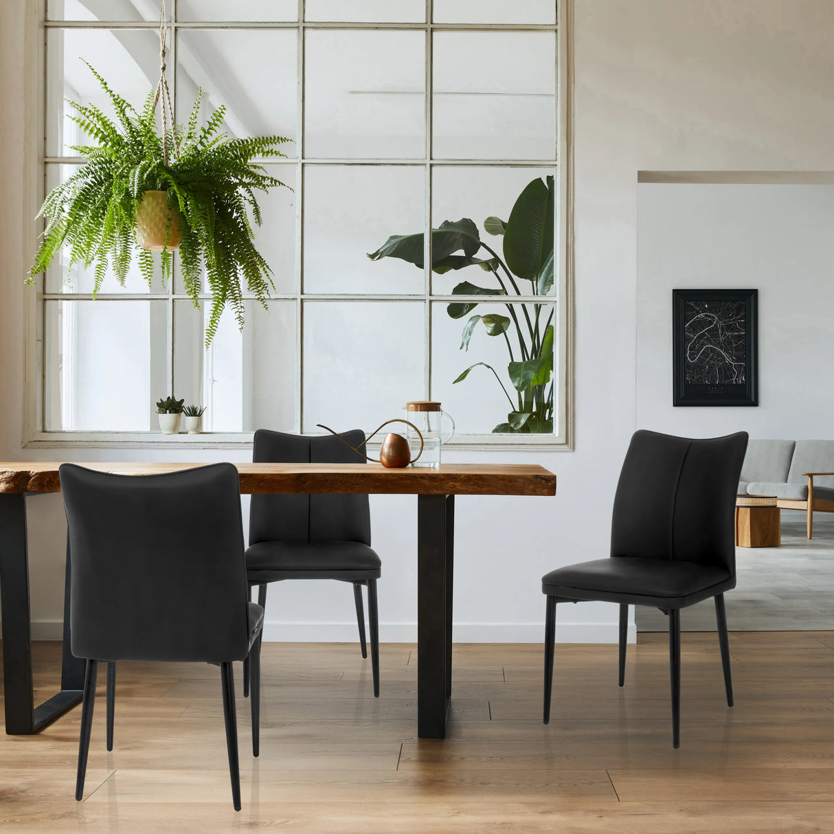 Drei schwarze Esszimmerstühle VISETO mit gesteppten Rückenlehnen an einem Holztisch von hjh LIVING