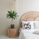 Kunstpflanze DRACAENA I in Grün mit einem dunklen Topf auf einem Beistelltisch von hjh OFFICE