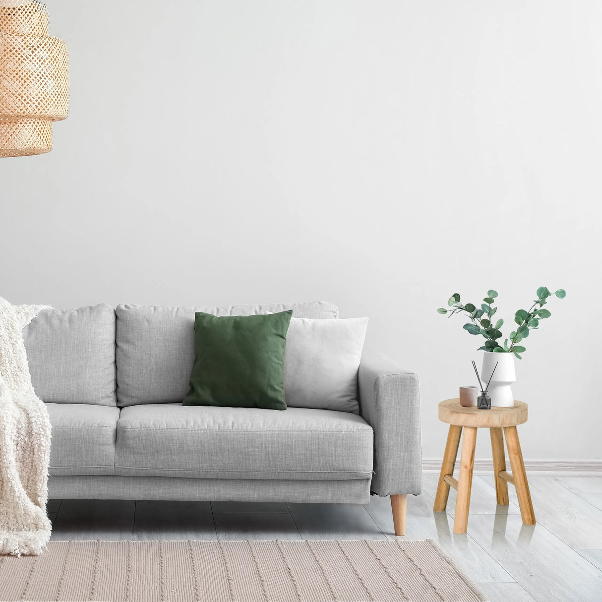 Brauner hölzerner Sitzhocker RUSTIKO W als Beistelltisch neben einem grauen Sofa von hjh LIVING