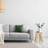 Brauner hölzerner Sitzhocker RUSTIKO W als Beistelltisch neben einem grauen Sofa von hjh LIVING