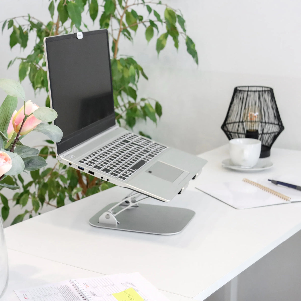 Silberne Laptopunterlage LAPTOP STAND mit verstellbarem Gestell auf einem weißen Schreibtisch von hjh OFFICE