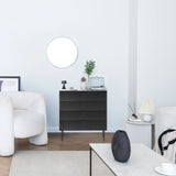 Schwarze Kommode KARBY K mit drei Schubladen und schlanken Metallfüßen in einem hellen Wohnraum von hjh LIVING