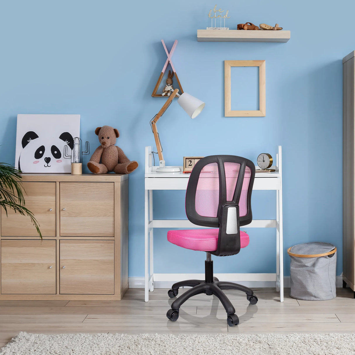 Rosa Kinderdrehstuhl KID YU 200 mit Netzrückenlehne und Rollen an einem weißen Schreibtisch von hjh OFFICE