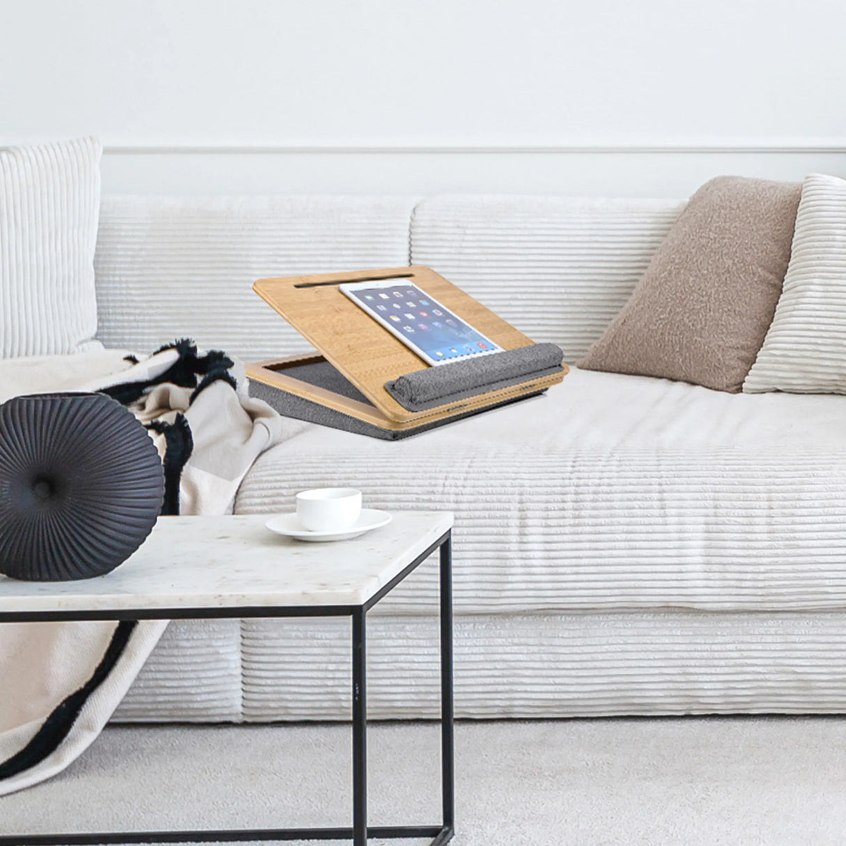 Braune Laptopunterlage COMFILAP III mit grauem Kissen auf einem hellen Sofa von hjh OFFICE