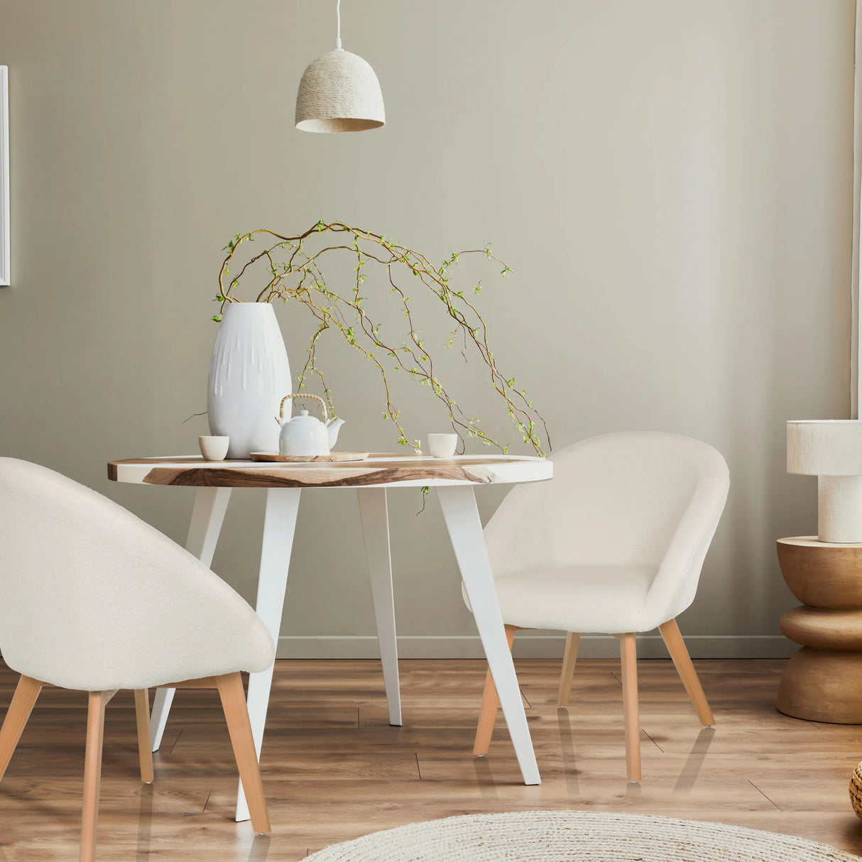 Zwei weiße Polsterstühle SCANDI TED mit hellen Holzbeinen an einem runden Tisch von hjh LIVING