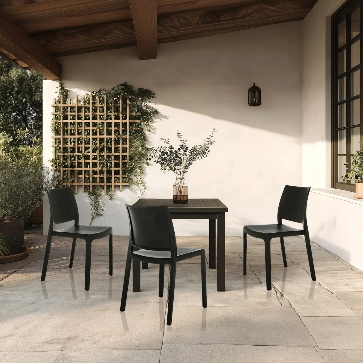 Drei schwarze Outdoor-Stühle T37 V mit passendem Tisch auf einer Terrasse von hjh LIVING
