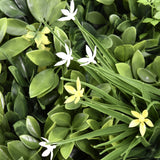 Grüne Blätter mit kleinen weißen und gelben Blüten der Pflanzenmatte LEAFLUXE WALL 2 von hjh LIVING