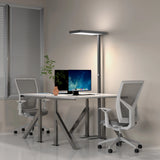 Schwarze LED Stehlampe LUMANOVA mit flachem Schirm neben einem weißen Schreibtisch von hjh OFFICE
