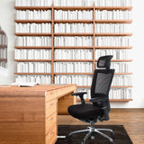 Schwarzer High-End-Bürostuhl NOVA PRO I mit Kopfstütze und Netzrücken vor einem Holzschreibtisch von hjh OFFICE