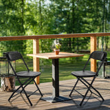 Zwei schwarze Outdoor-Stühle TUDELA XXL PRO mit perforierter Sitzfläche an einem Holztisch von hjh OFFICE