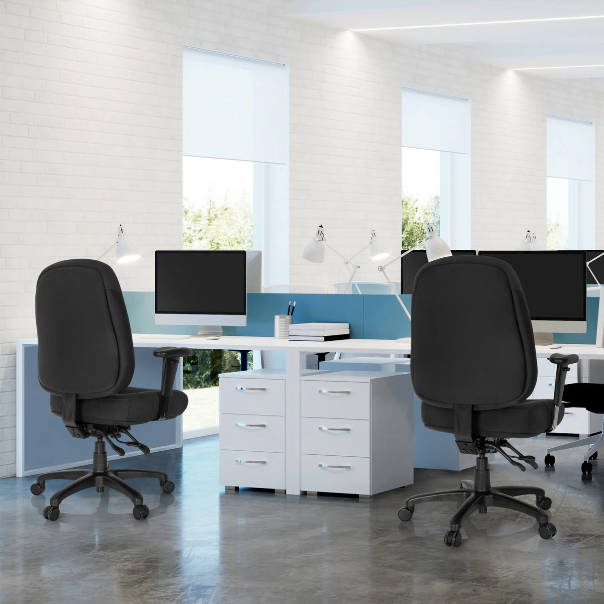 Zwei schwarze Profi-Bürostühle ZENIT XXL an weißen Schreibtischen in einem hellen Büro von hjh OFFICE