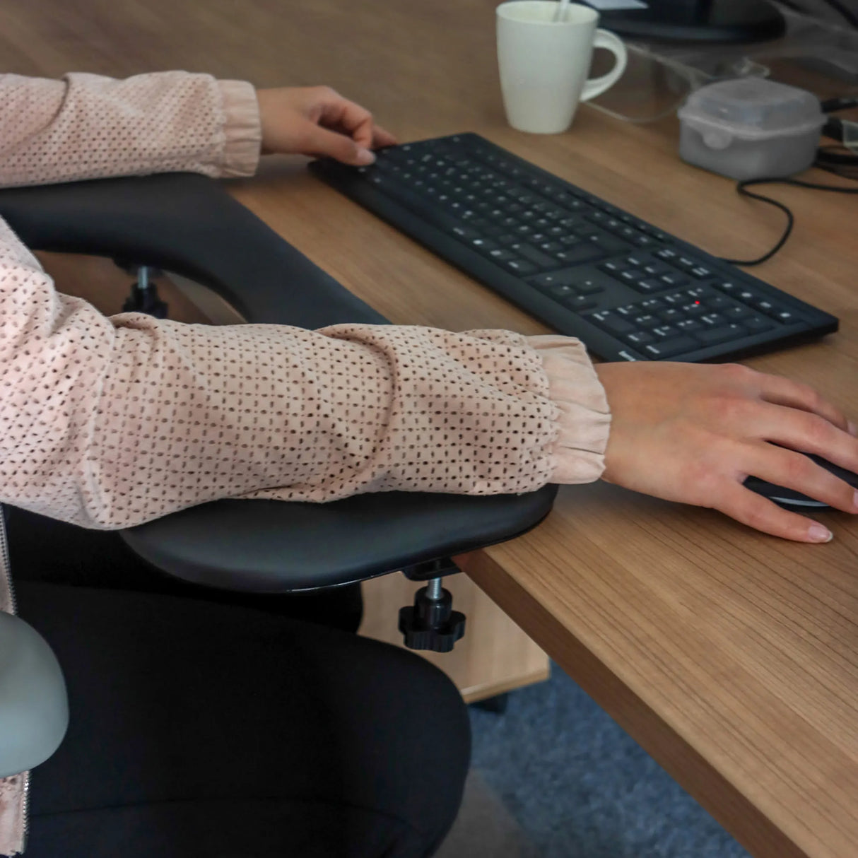 Schwarze Armstütze des Modells RELEX RT2 an einem Schreibtisch mit Tastatur und Maus von hjh OFFICE