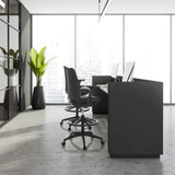 Zwei schwarze Counterstühle NESTORA WORK mit Fußring und Rollen an einem modernen Schreibtisch von hjh OFFICE