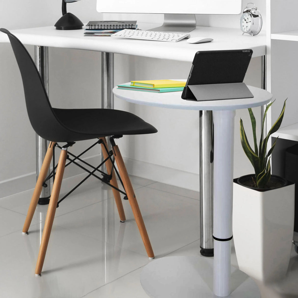 Weißer Stehschreibtisch STAND III mit runder Ablagefläche, schwarzem Stuhl und einer Zimmerpflanze von hjh OFFICE