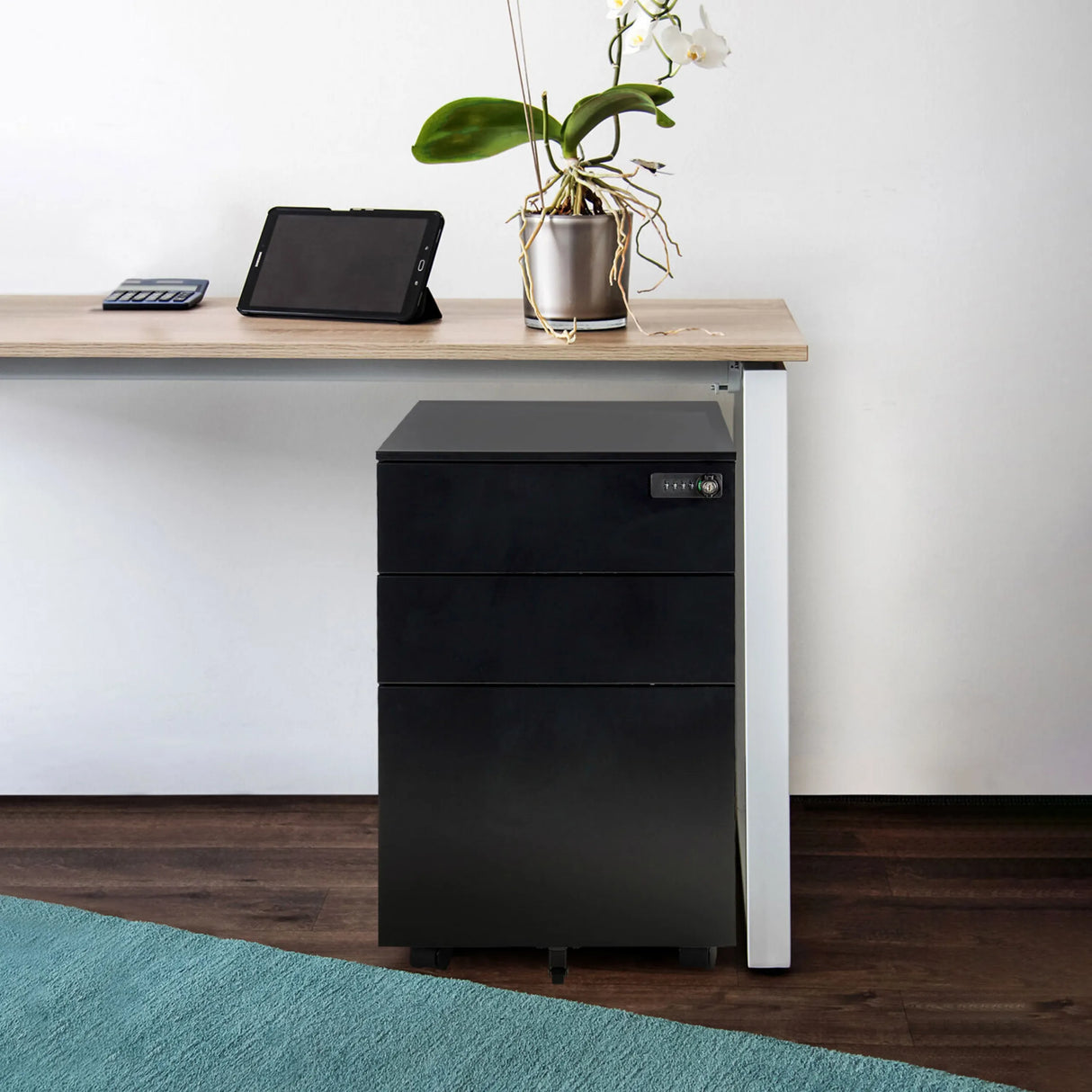 Schwarzer Metall-Rollcontainer COLOR OS I mit drei Schubladen und Rollen unter einem Schreibtisch von hjh OFFICE