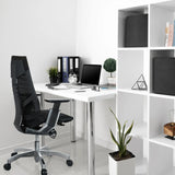 Schwarzer High-End-Bürostuhl GENIDIA mit Netzrückenlehne an einem weißen Schreibtisch von hjh OFFICE