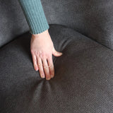 Grauer Stoffbezug der Sitzfläche des Loungesofas HAYRIVER unter einer Hand von hjh LIVING