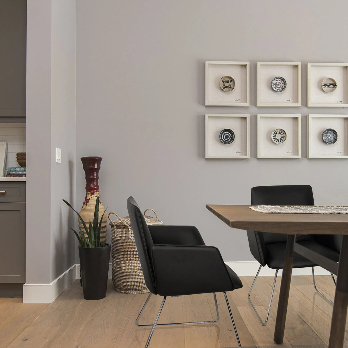 Schwarzer Polsterstuhl DESIGNIA V mit schlanken Metallbeinen an einem Holztisch von hjh OFFICE